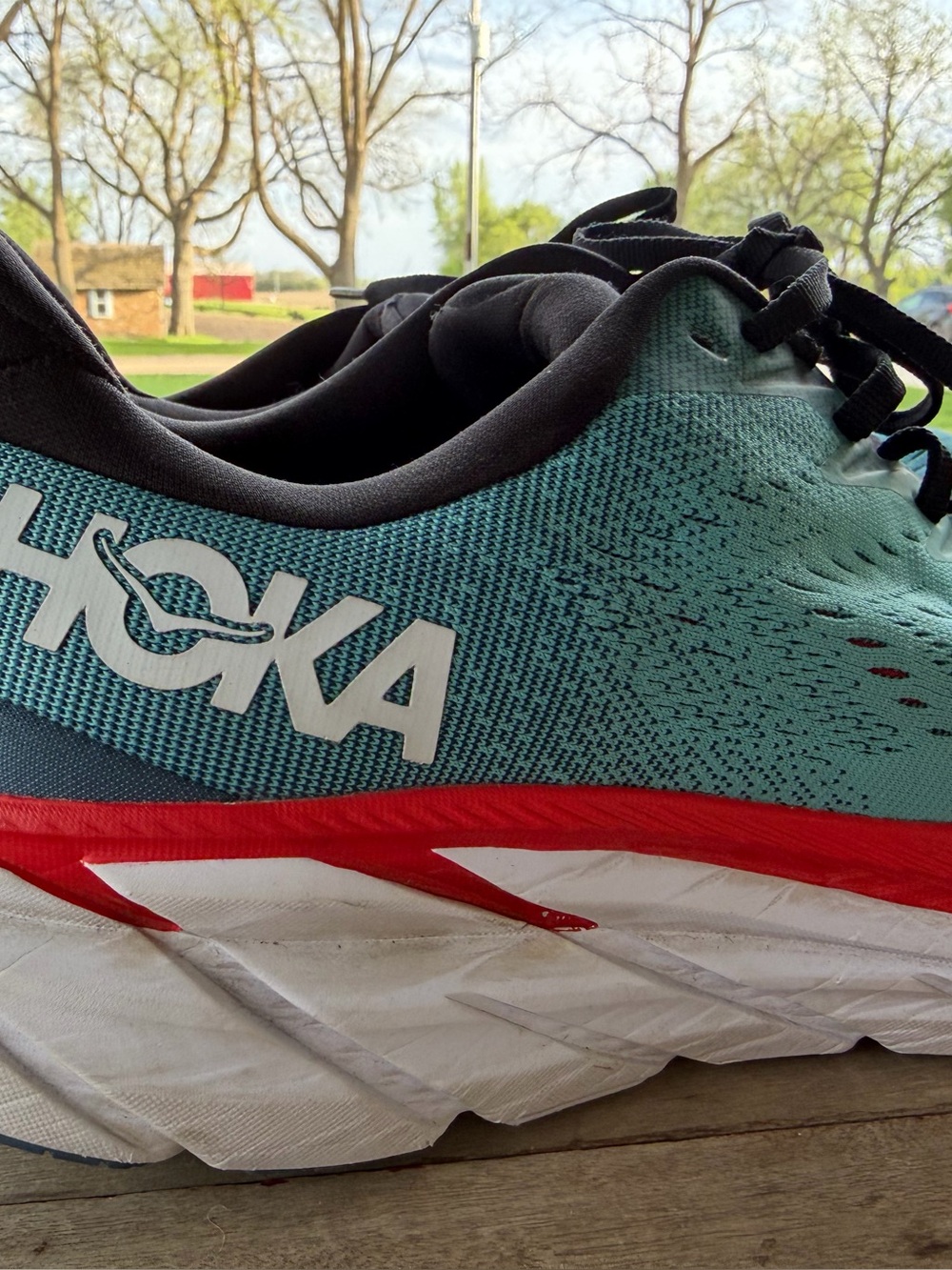 Hoka teal and red road running shoe